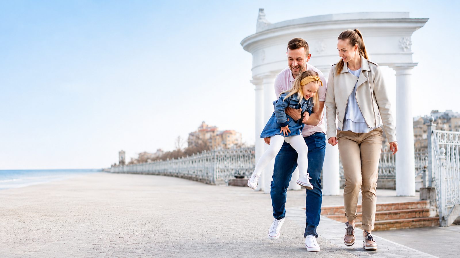Familia paseando por un paseo marítimo en España